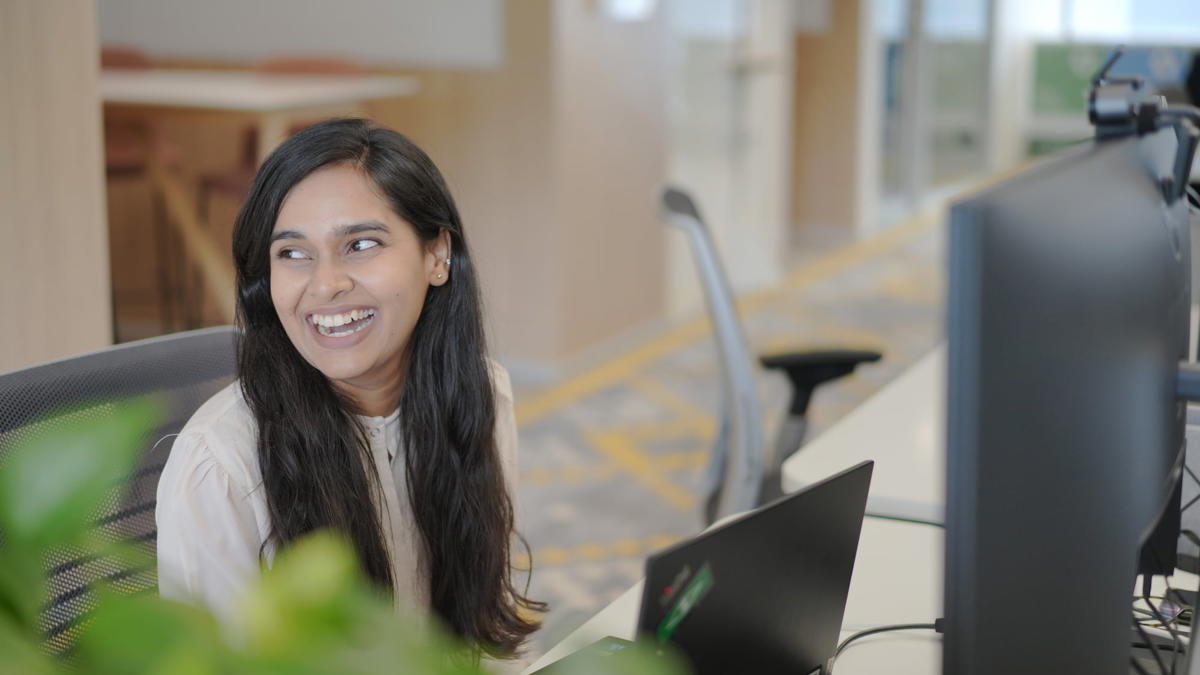 a person smiling at a computer