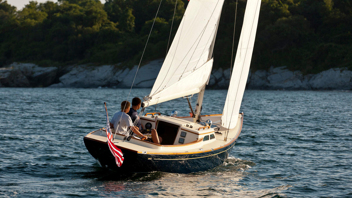 a couple of men on a sailboat