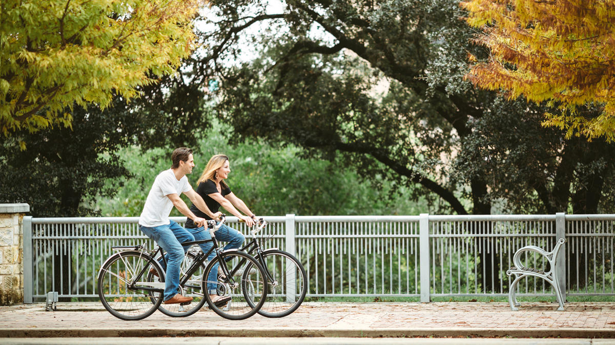 a person and person riding bicycles on a sidewalk