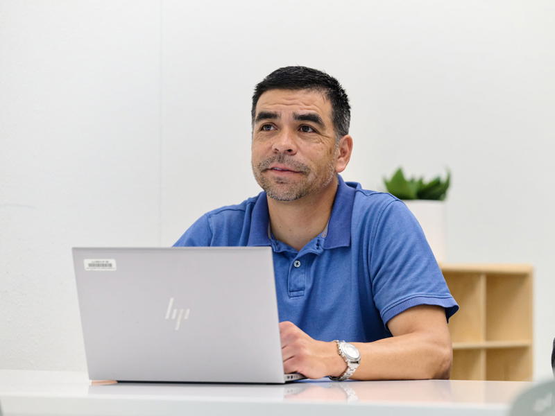 a person sitting at a desk with a laptop