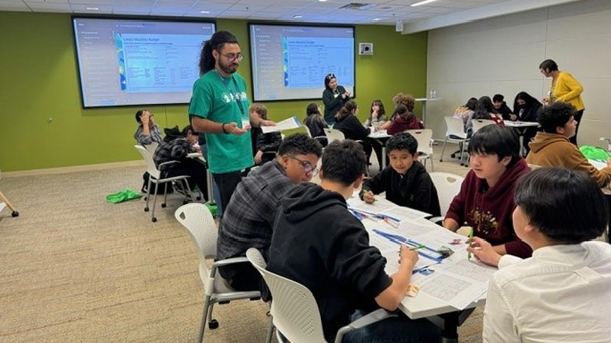 a group of people sitting at a table in a classroom