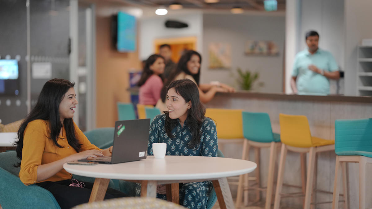 a person sitting at a table with a laptop