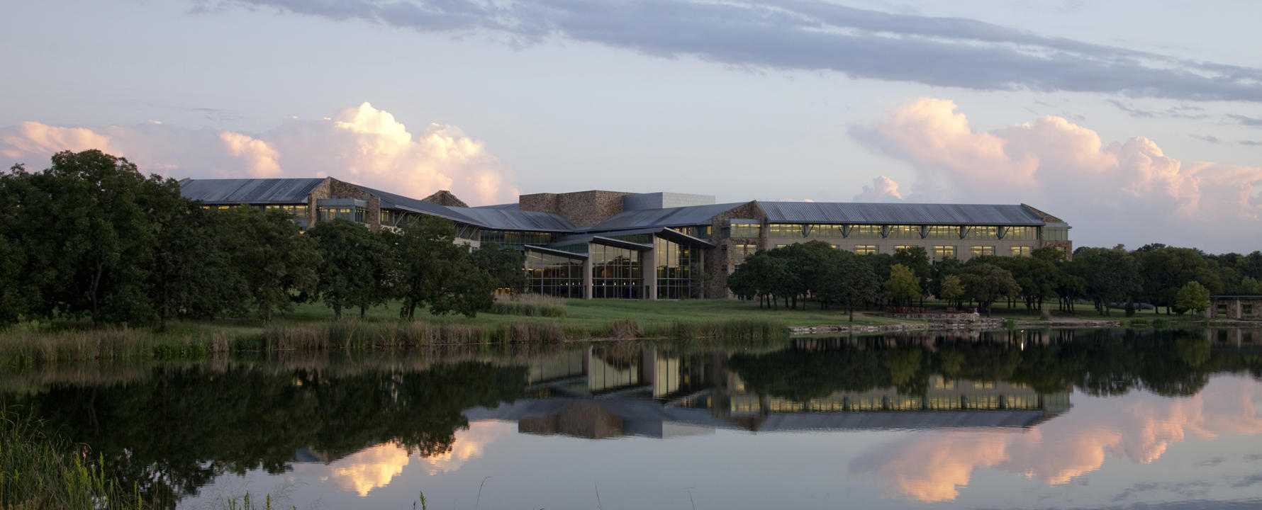 a building with trees and a body of water