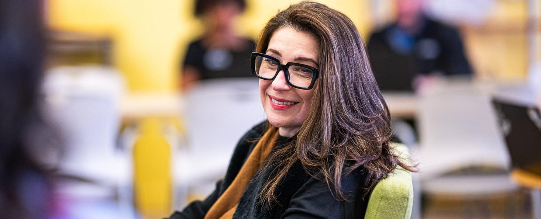 a person wearing glasses and smiling