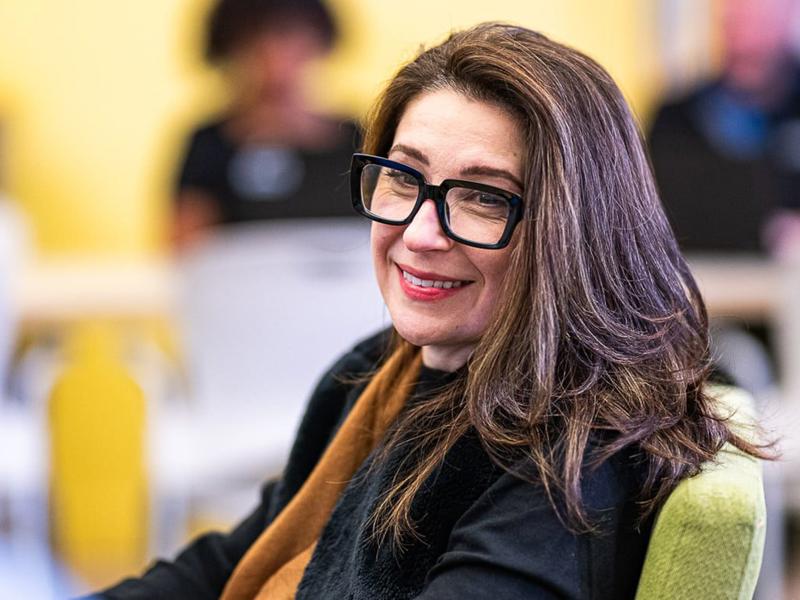 a person wearing glasses and smiling