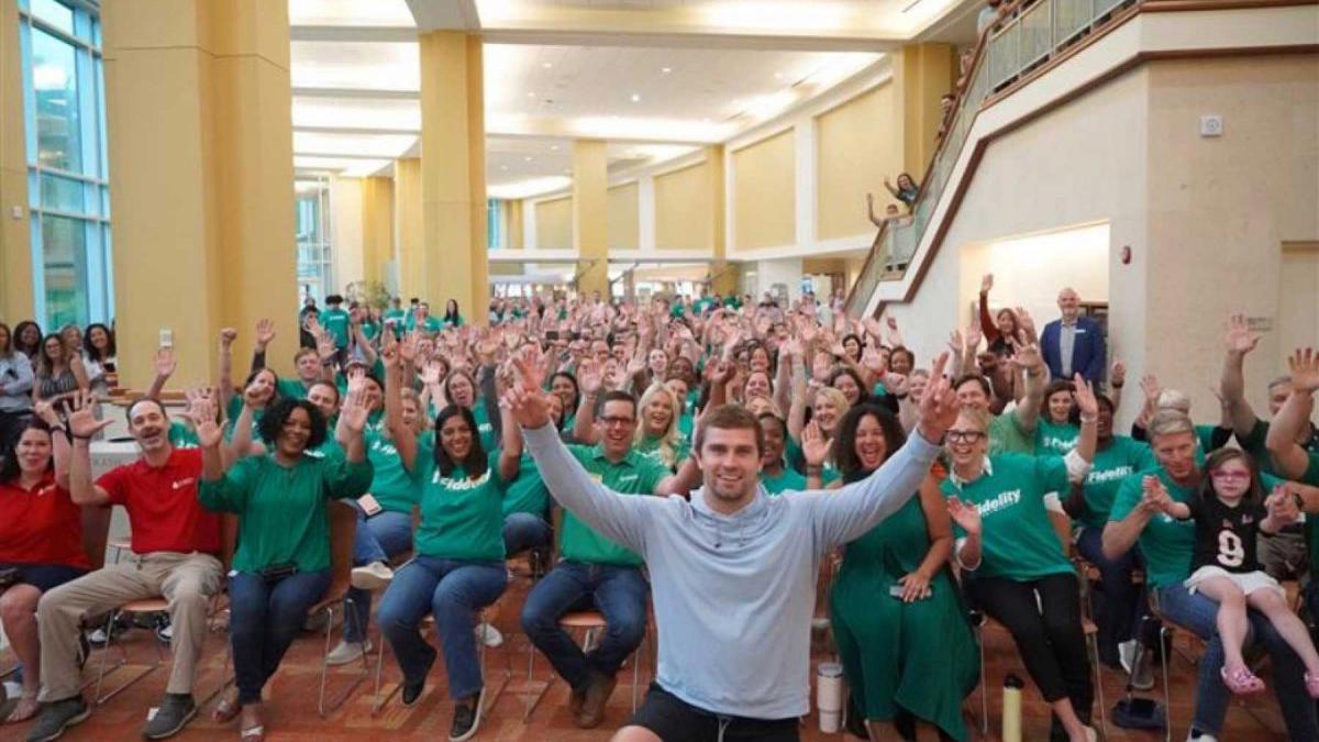 a group of people sitting in chairs with their hands up