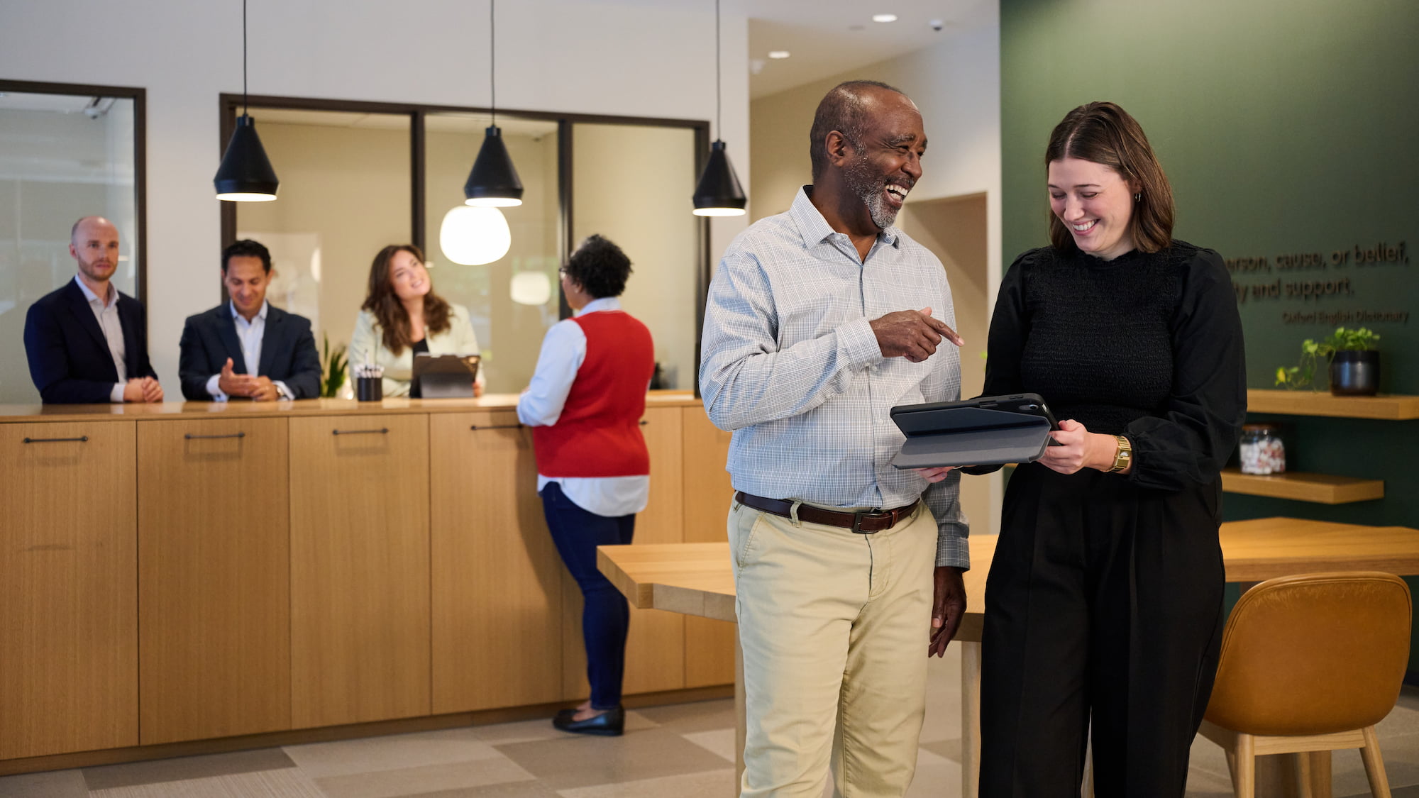 a person and person standing in a room with a laptop