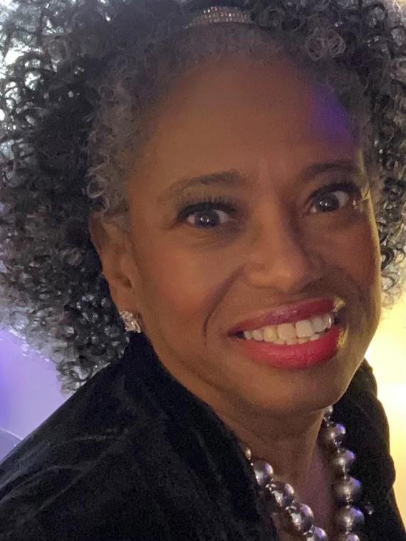 a person with curly hair smiling