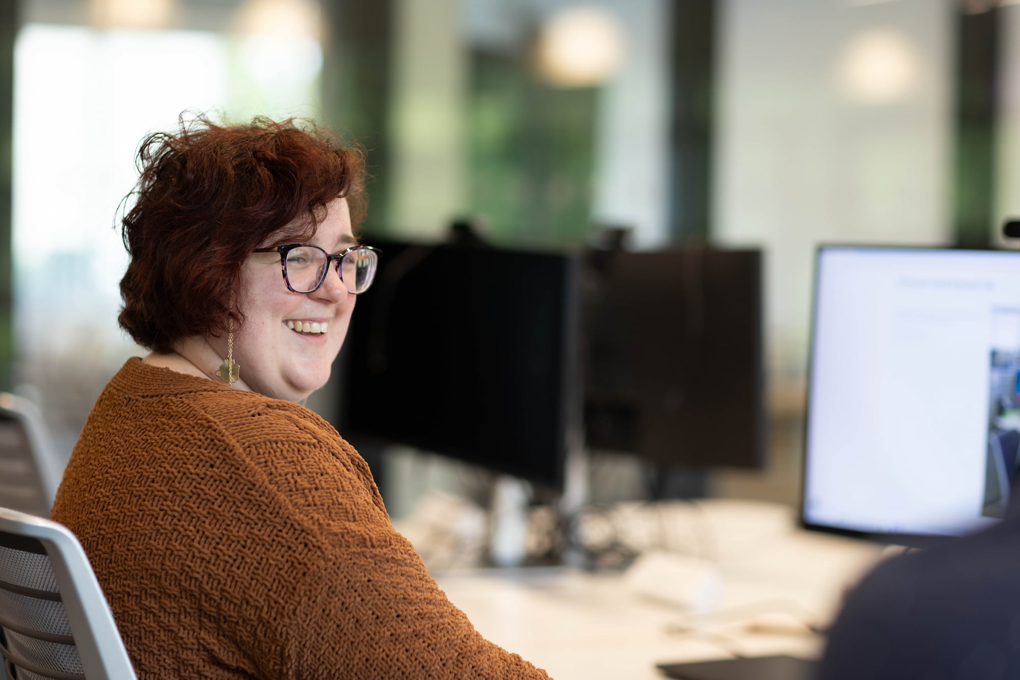 a person smiling at a computer