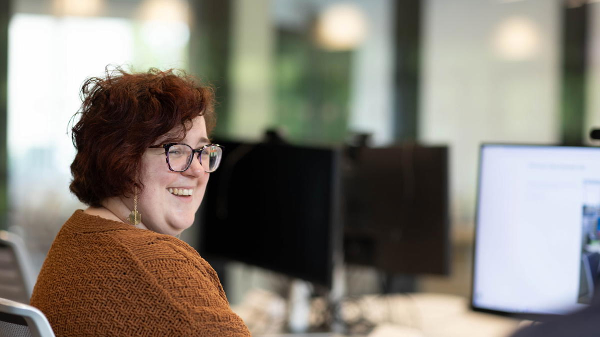 a person smiling at a computer