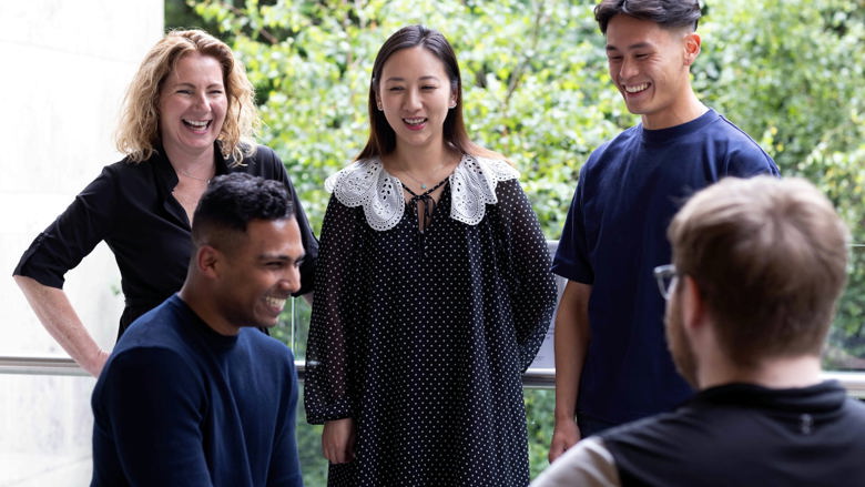 A group of young adults laughing on an office patio