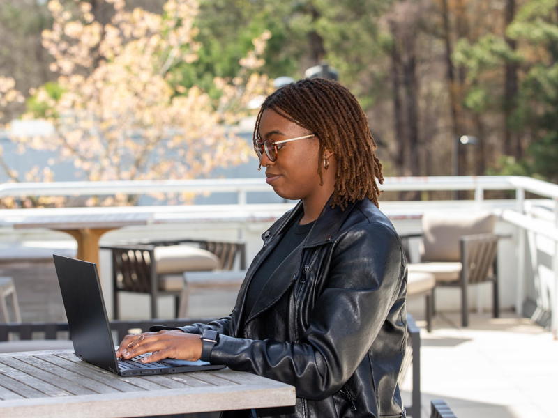 a person sitting at a table with a laptop