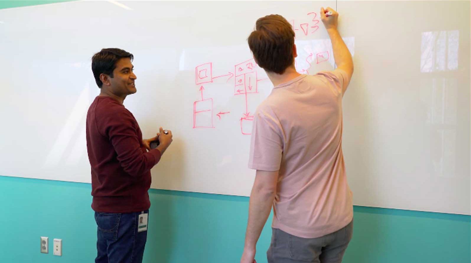 a person writing on a whiteboard