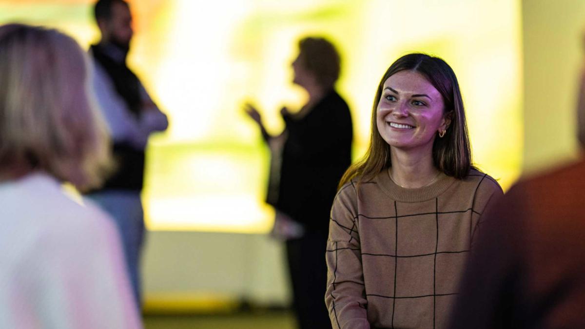a person smiling in front of a crowd