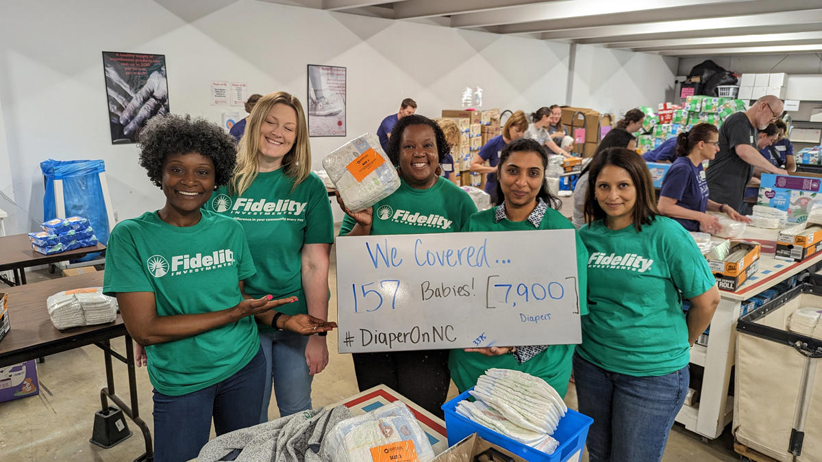 a group of women in green shirts holding a sign