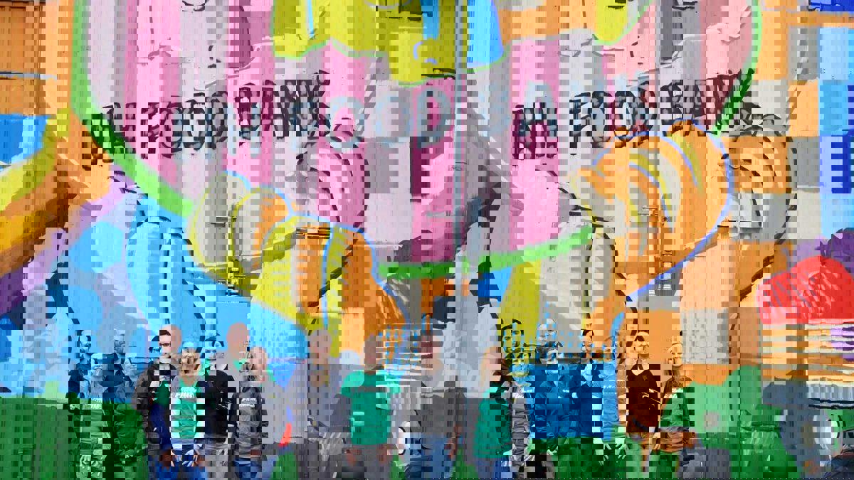 a group of people posing for a photo in front of a colorful wall