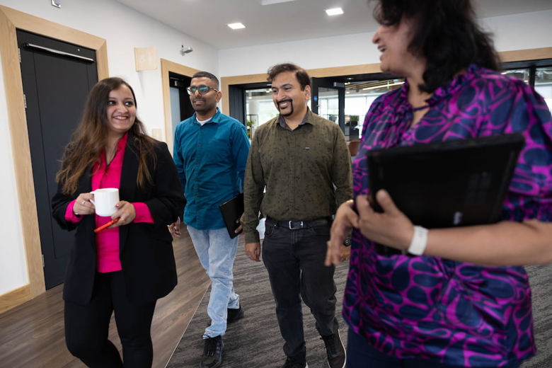 a group of Fidelity Ireland employees talking casually while they walk through an office
