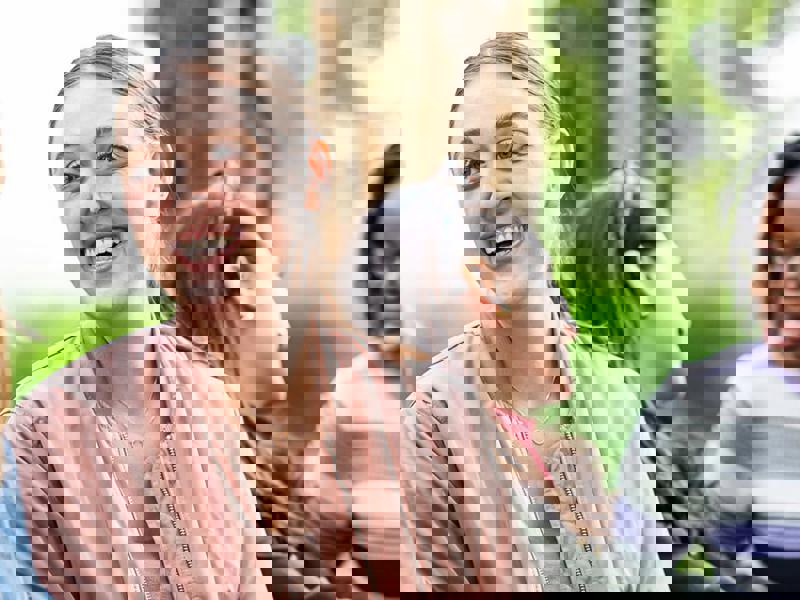 a person smiling and sitting next to another person