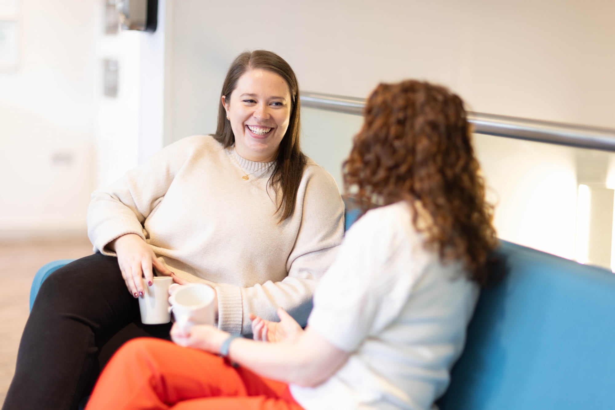 two women sitting on a blue couch
