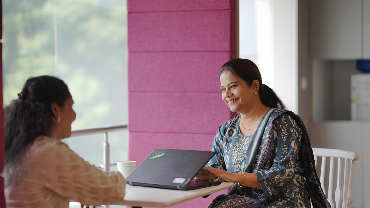 a person sitting at a table with a laptop