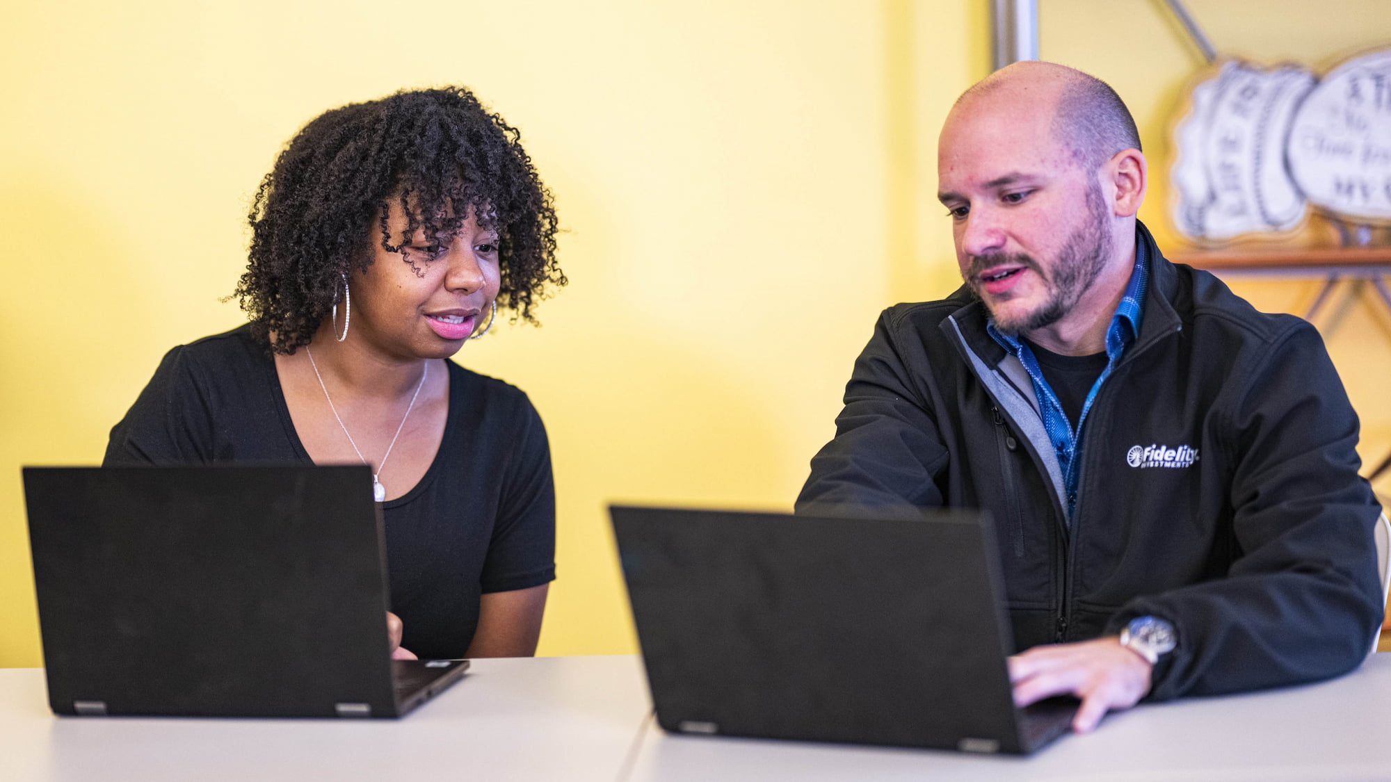 a person and person looking at laptops