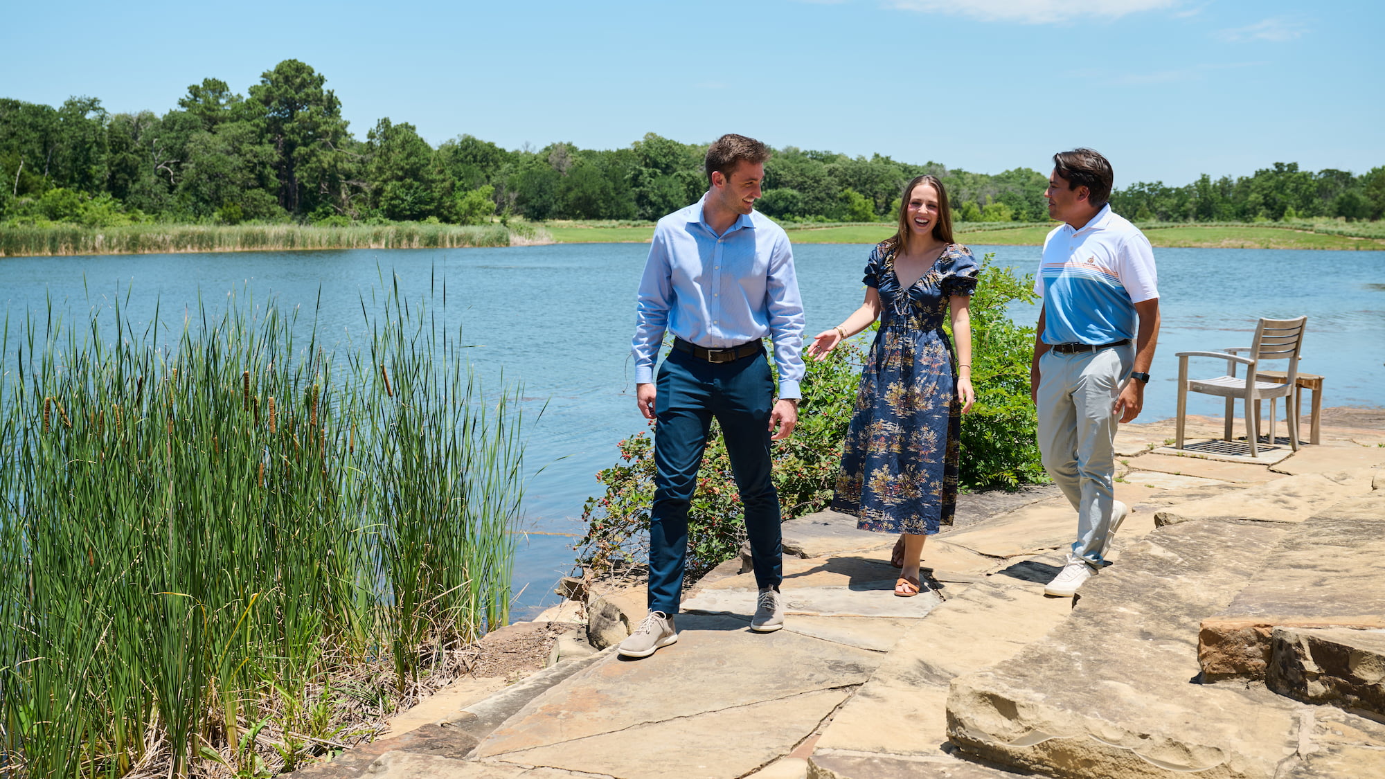 a group of people walking by a lake