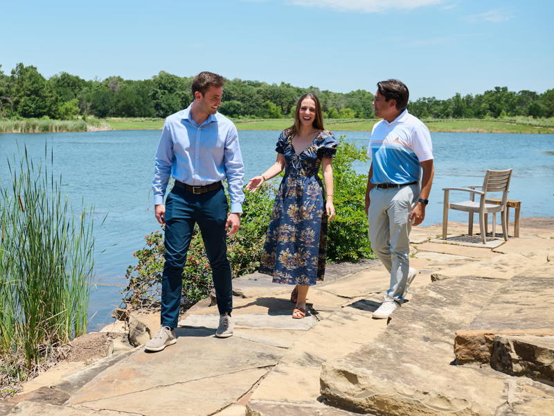 a group of people walking by a lake
