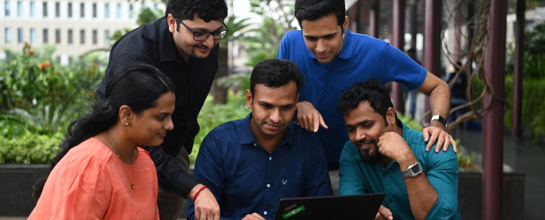 a group of people looking at a laptop
