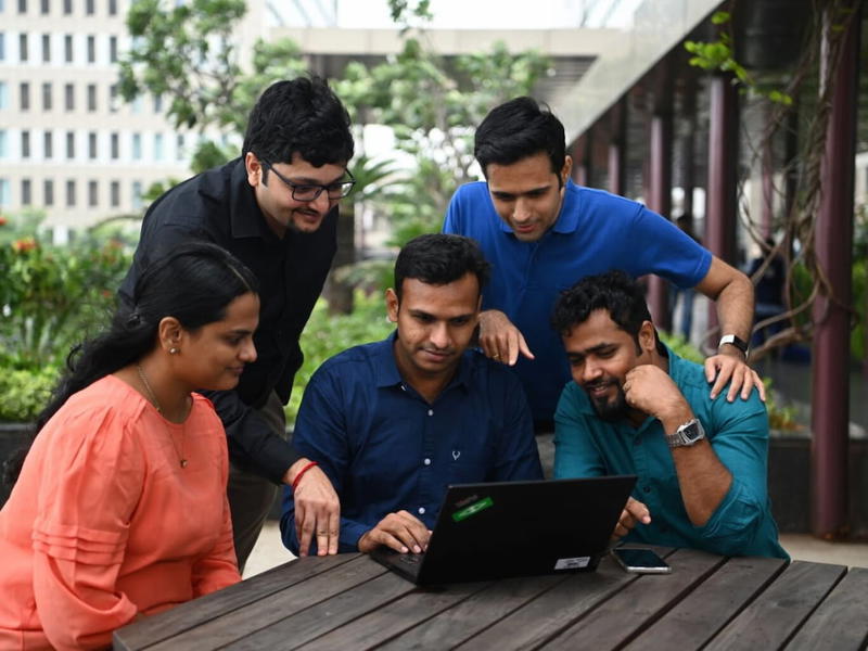a group of people looking at a laptop