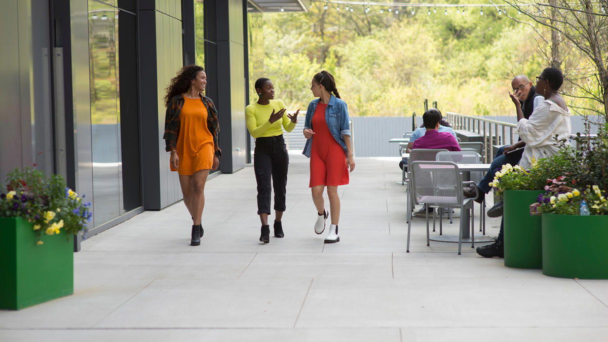 a group of women walking on a sidewalk